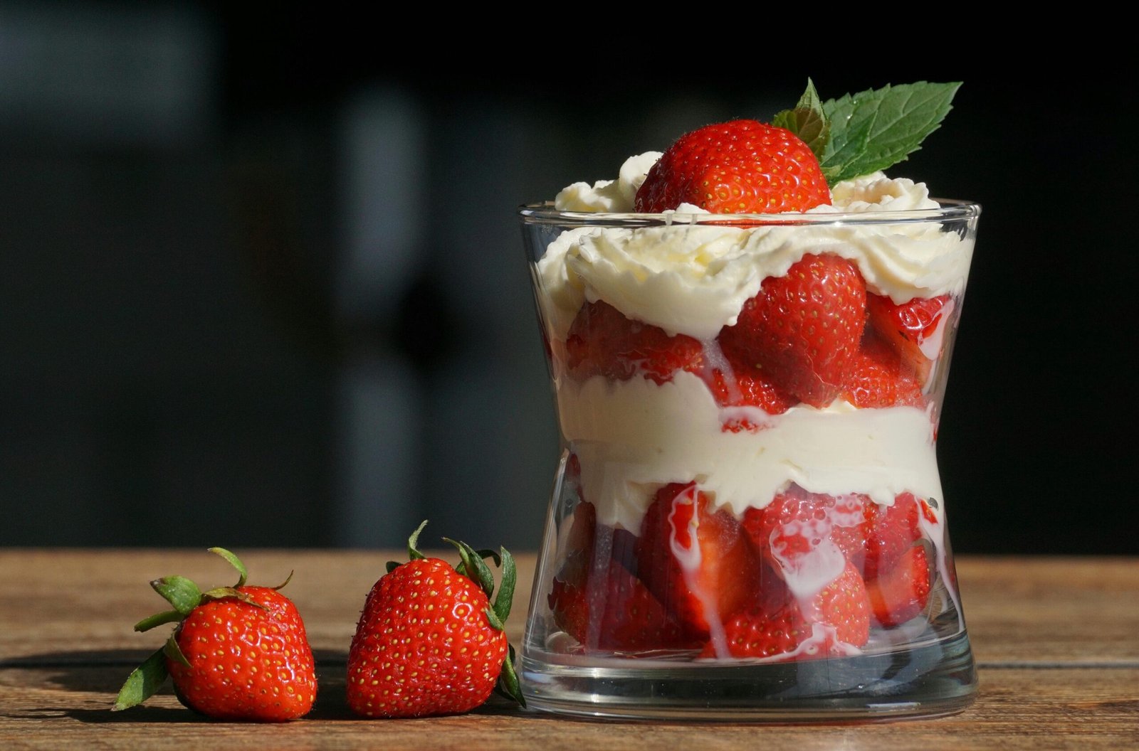 Delicious strawberry dessert layered with cream in a glass, perfect for a summer treat.