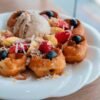 Tasty waffles topped with ice cream and fresh berries, perfect for a sweet breakfast.